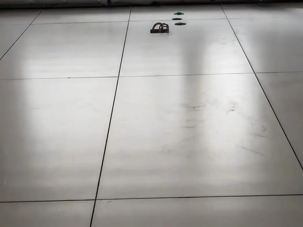 Light reflecting across installed floor tiles showing possible roller marks